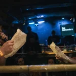 Punchline rap contenders en salle de battle, MC a cappella près des micros