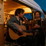 Le baladeur open mic : guitariste dans un van aménagé, public en extérieur